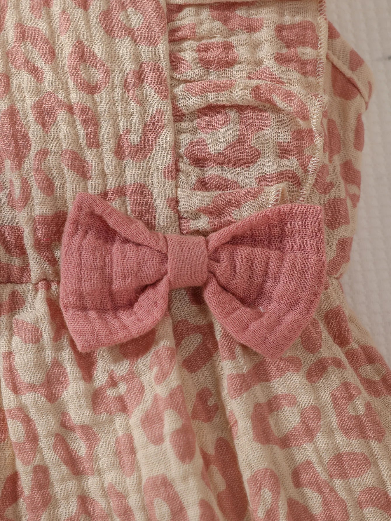 Baby girl summer pink jumpsuit with bow detail and matching headband, made by Baby Bubble, perfect for warm weather.