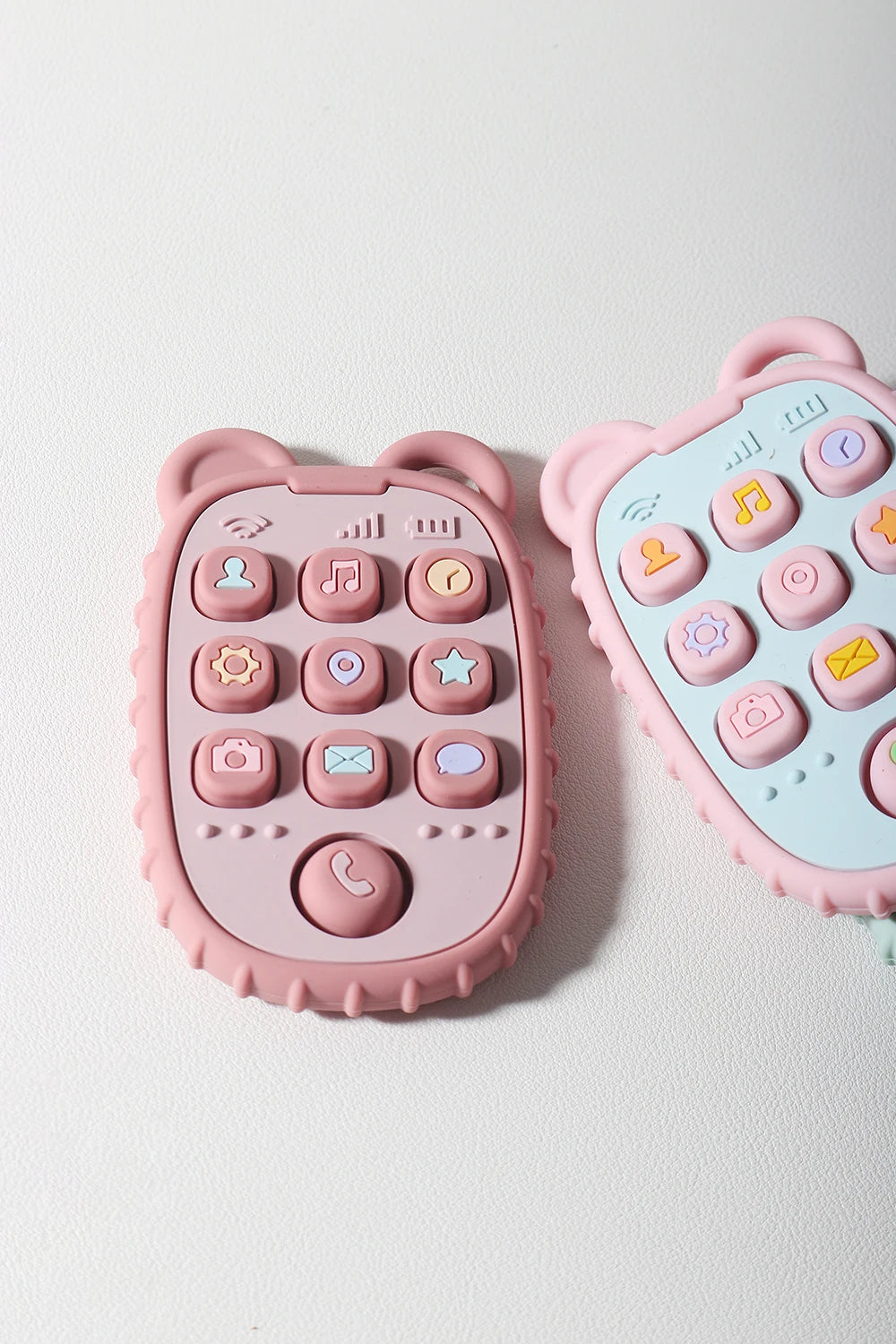 Baby Bubble baby phone shape teether made of silicone, fun chew and soothe toy with bright colors and textured surface for teething relief.