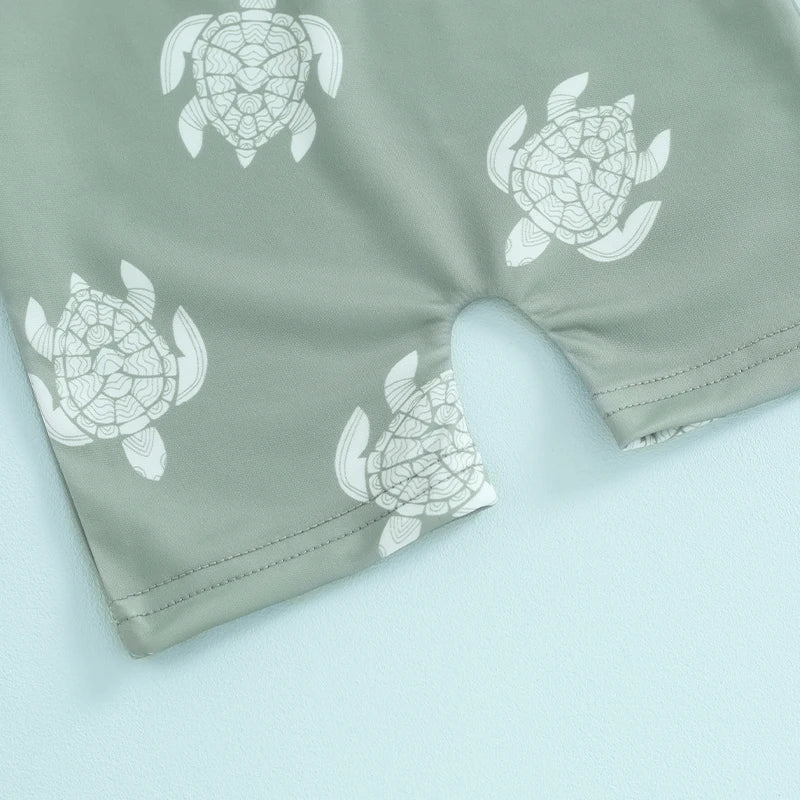 Baby boys rash guard set with turtle and dinosaur print from Baby Bubble, featuring colorful and playful sun protection swimwear.