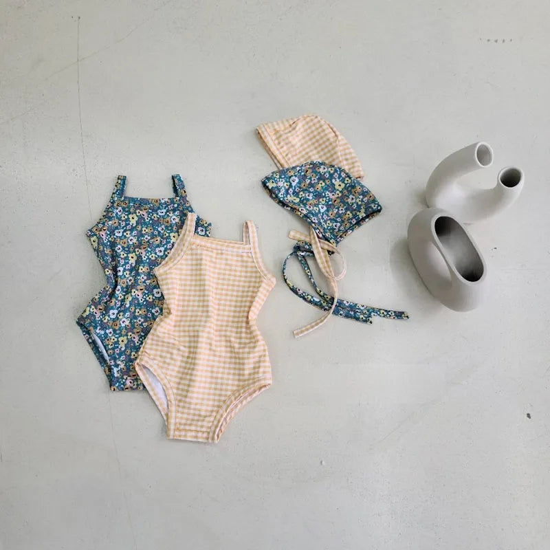 Baby girl swimwear set with one-piece swimsuit and sun hat from Baby Bubble, featuring bright colors and playful design.