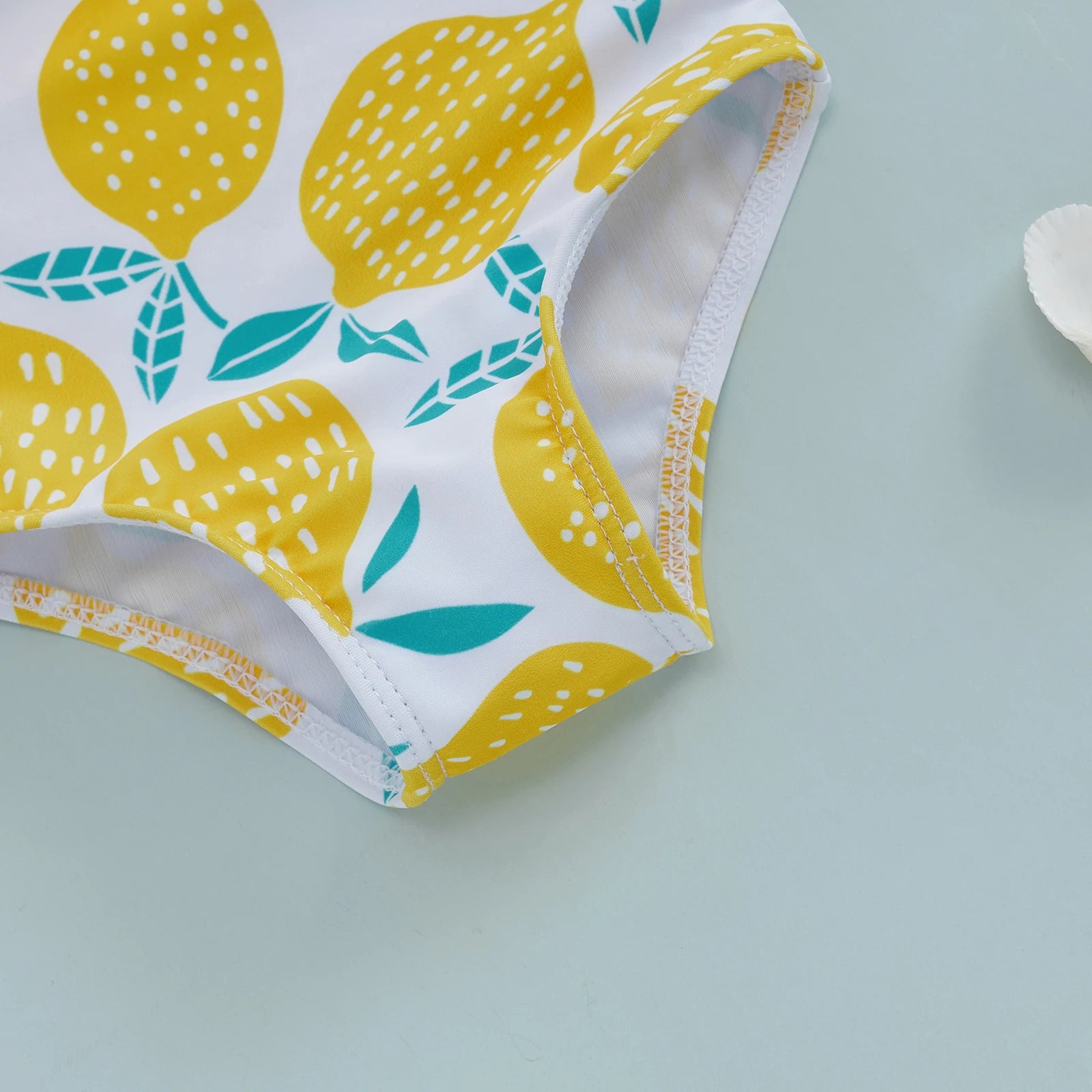 Baby Girl's one-shoulder swimsuit with lemon print, featuring ruffle details and adjustable straps for a cute swimwear look.