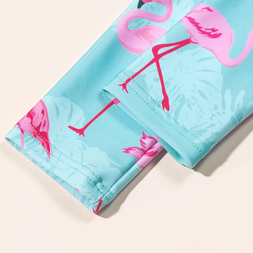 Girls Flamingo Swimsuit by Baby Bubble, long sleeve UV one-piece featuring colorful flamingo print, perfect for sunny beach days.