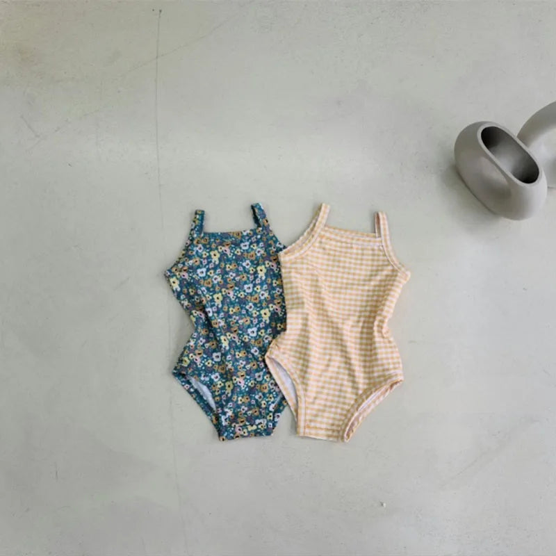 Baby Girl swimwear set with one-piece swimsuit and sun hat from Baby Bubble, featuring colorful floral patterns and sun protection elements.