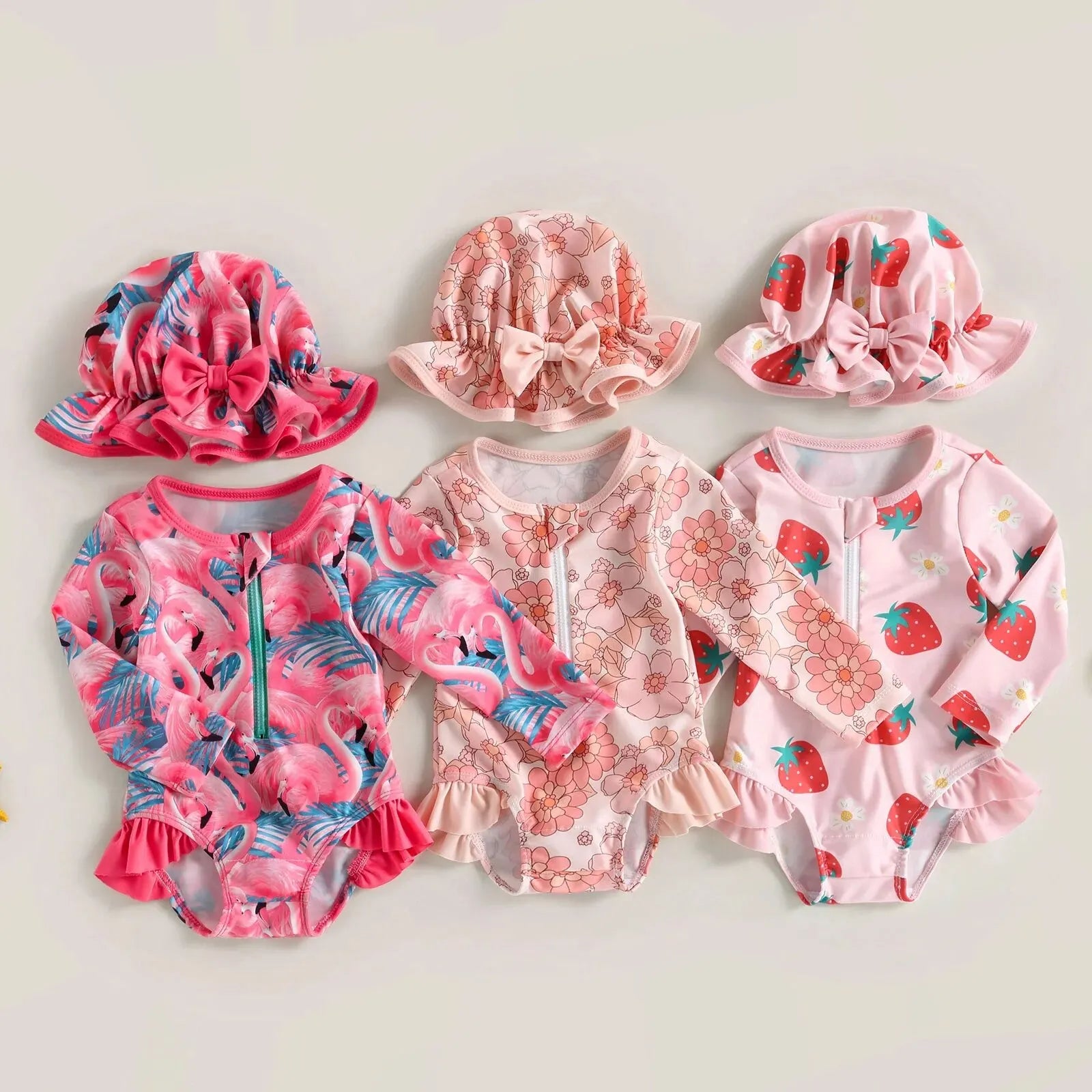Baby girl wearing a floral flamingo print one-piece swimsuit by Baby Bubble, featuring bright pink and green tropical floral design.