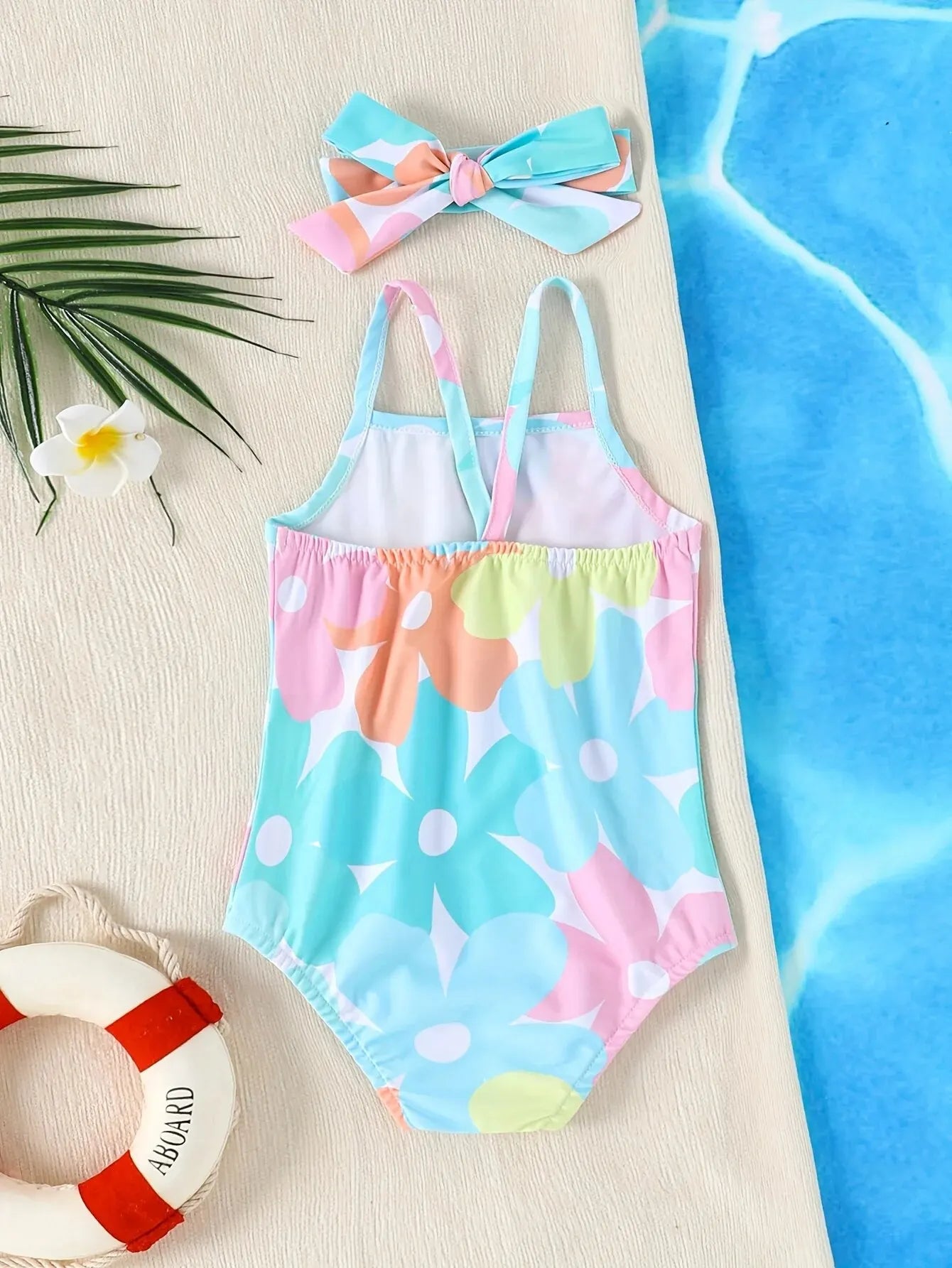 Baby Girl's one-piece swimsuit by Baby Bubble for newborns and toddlers, featuring colorful floral pattern and adjustable straps.