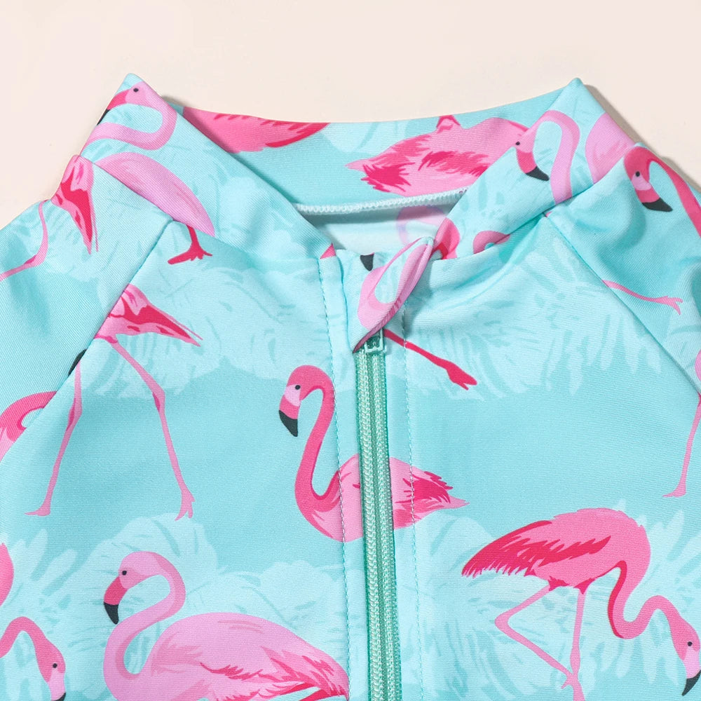 Girls flamingo swimsuit by Baby Bubble featuring long sleeves and UV protection, colorful flamingo print on a one-piece design.