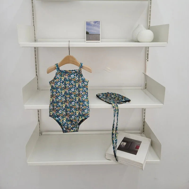 Baby Girl swimwear set with one-piece suit and sun hat, featuring colorful patterns and ruffle details, by Baby Bubble.