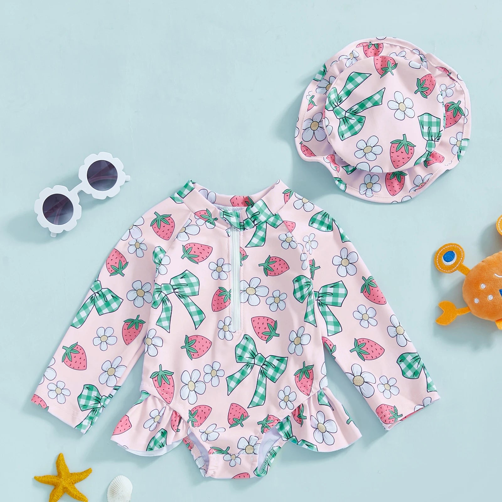 Baby girl wearing floral rash guard with hat, zip-up swimwear from Baby Bubble, perfect for sun protection and water activities.