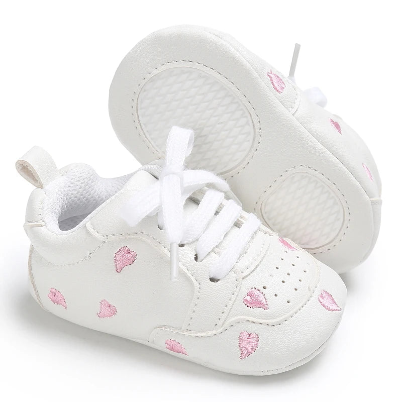 Baby girl soft sole crib shoes by Baby Bubble, first walker style, featuring pink and white design with cute bow details.