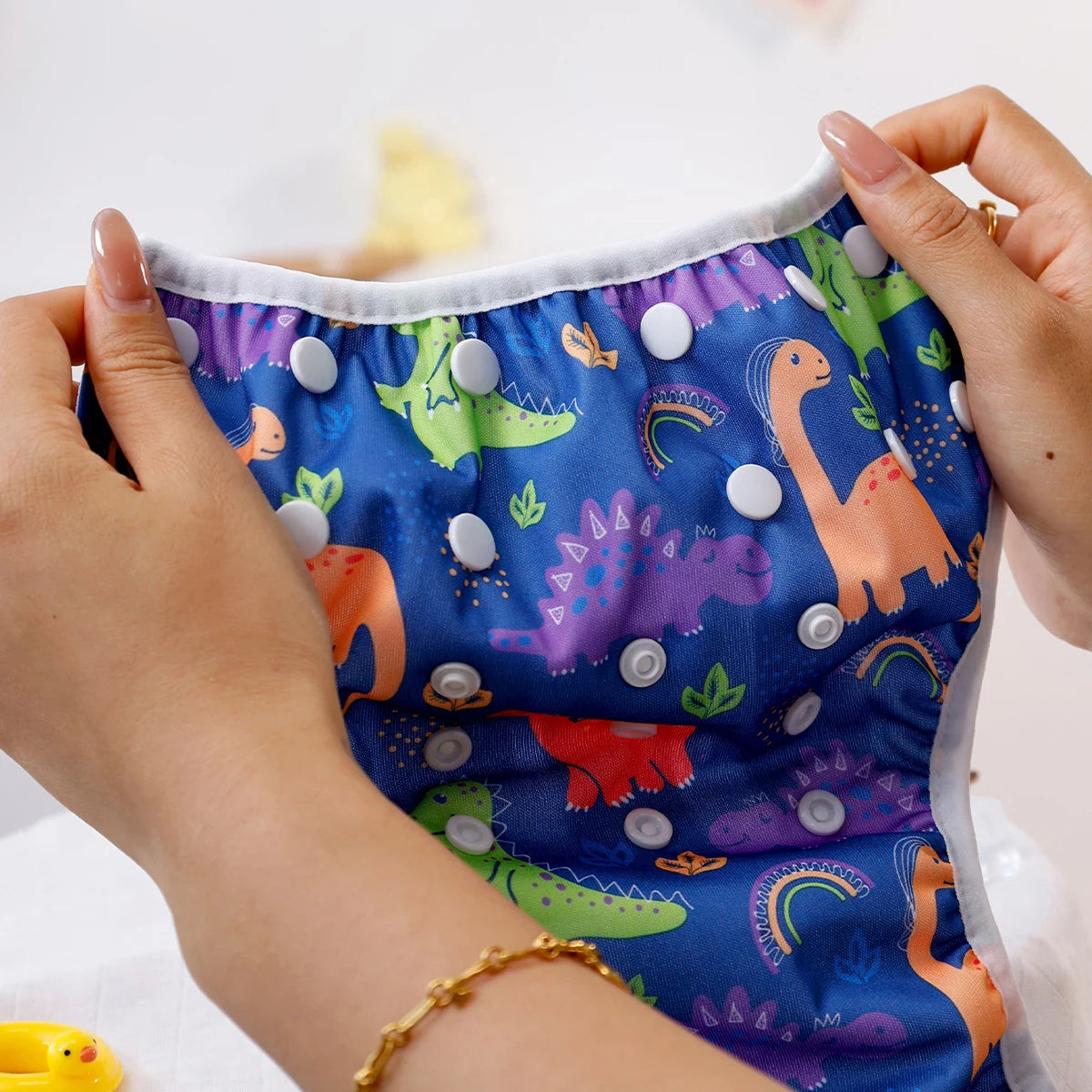 Baby Bubble reusable swim diapers with colorful animal print design, suitable for infants and toddlers during pool or beach outings.