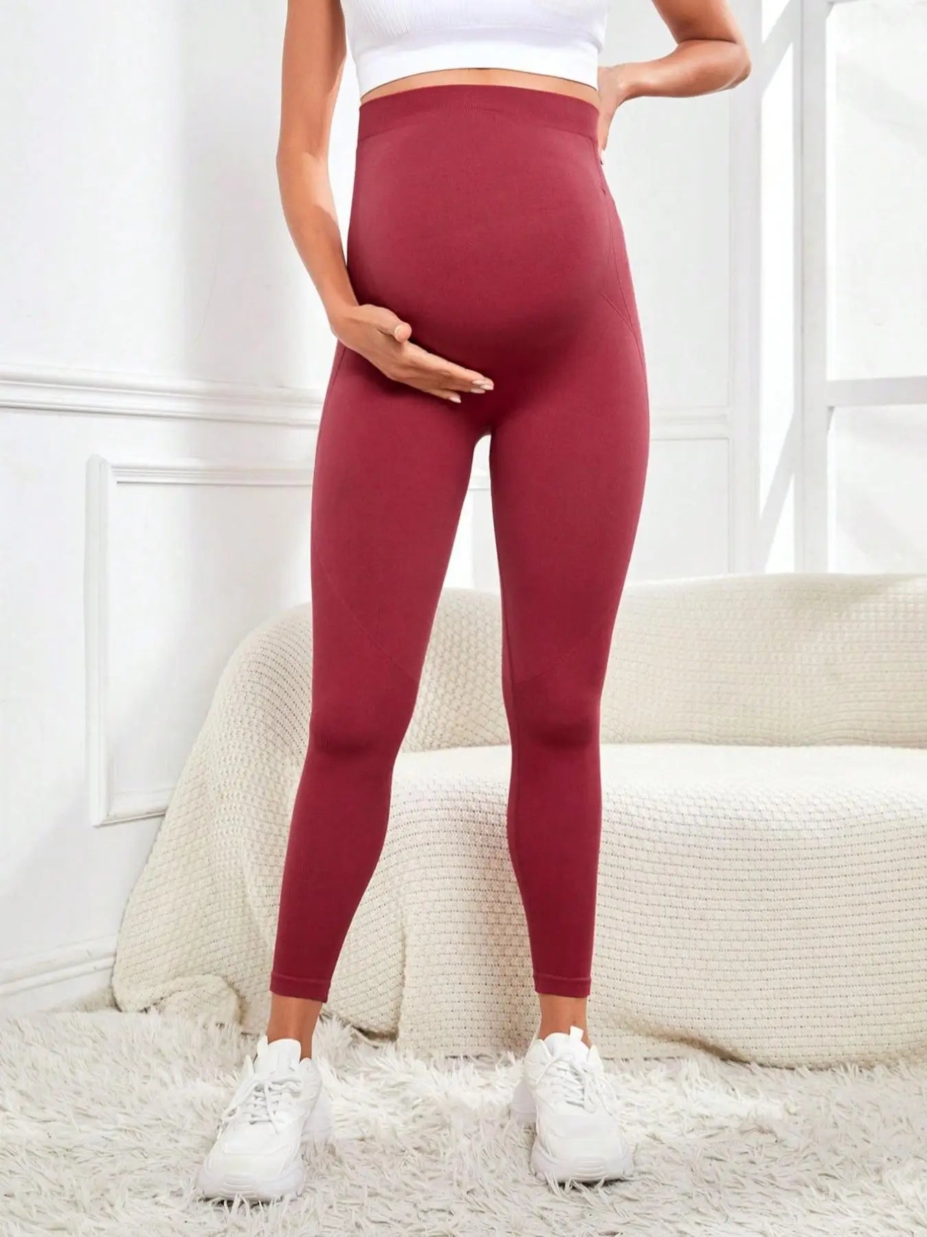 Pregnant woman wearing cozy knitted maternity leggings with warm belly support, showing comfortable fit and soft fabric.