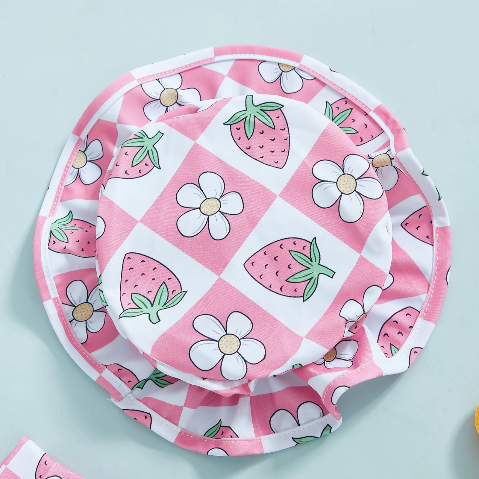 Baby girl wearing Baby Bubble floral zip-up rash guard with matching hat, suitable for sun protection and outdoor play.